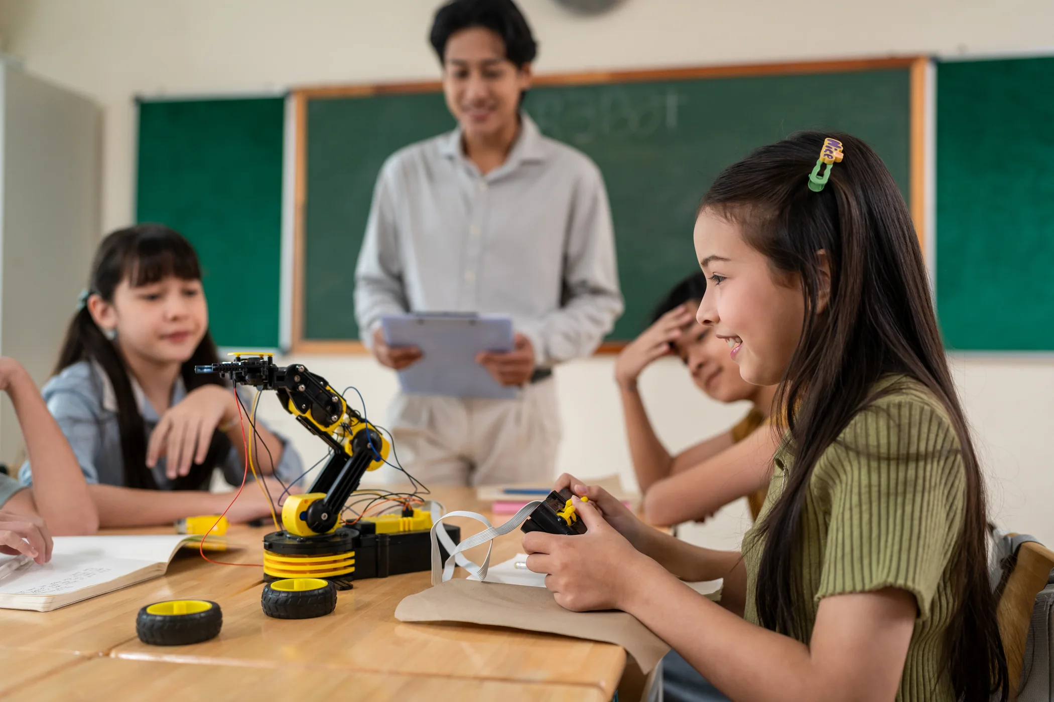 Students learning with a programmable robotic arm